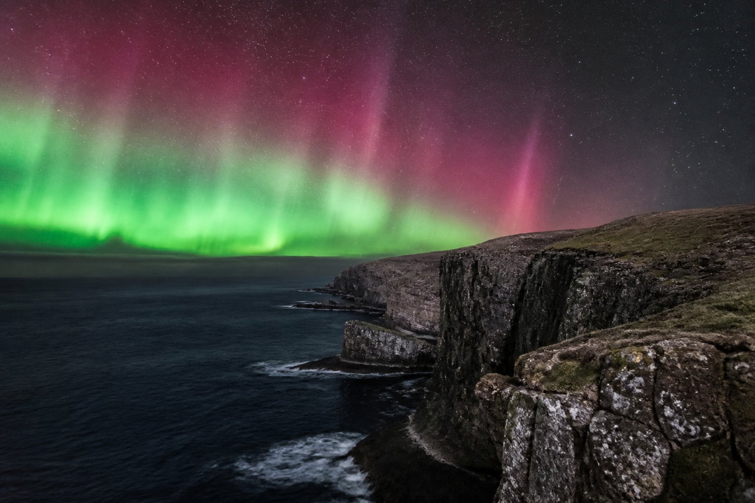 Aurora over Shetland sea cliffs