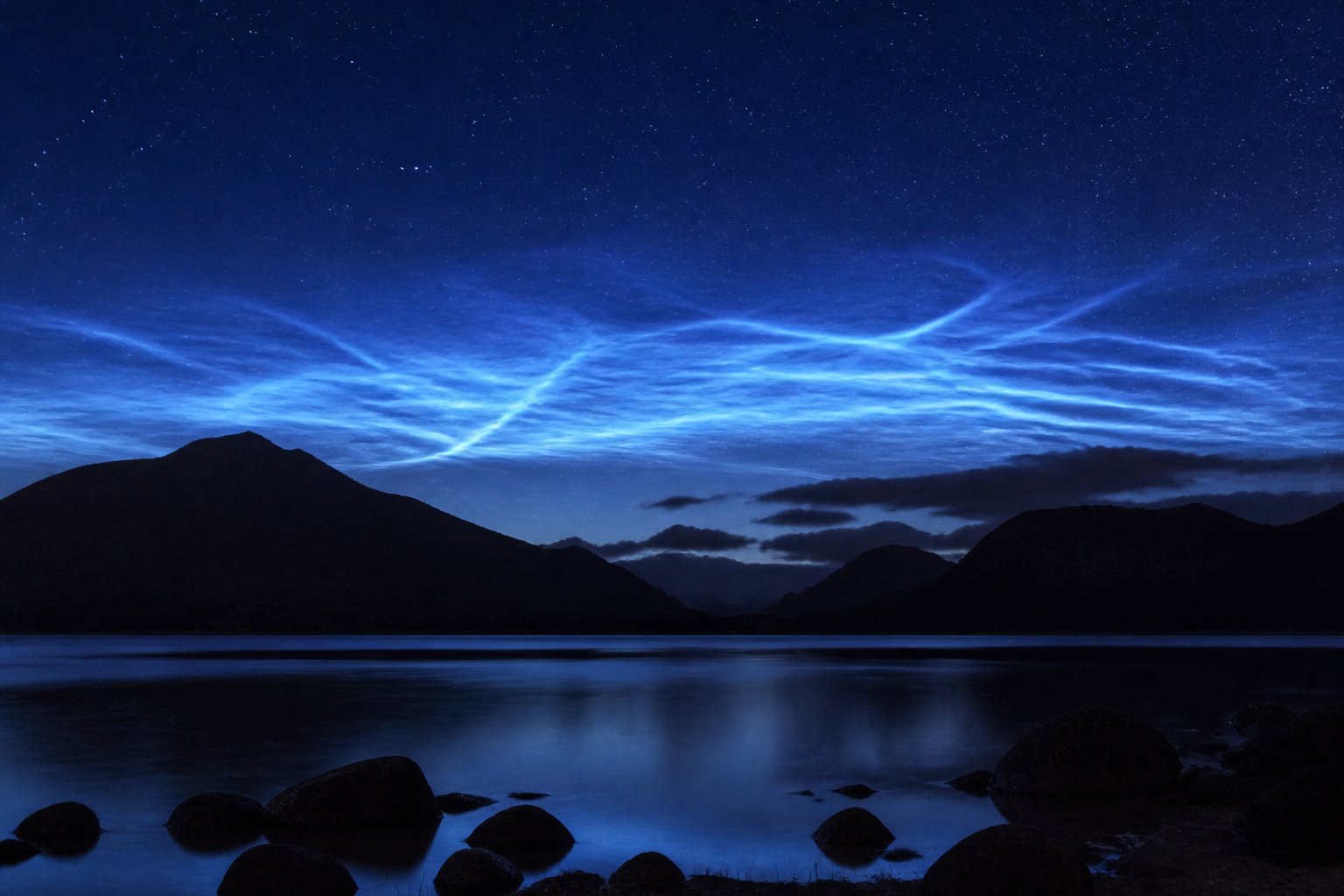 Electric-blue noctilucent clouds over a Scottish loch